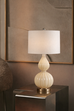 Decorative table lamp with a ribbed design on a reflective surface.