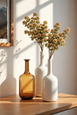Three vases on a wooden surface with a mountain landscape painting in the background