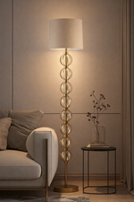 Decorative floor lamp in a living room setting with a sofa and side table.
