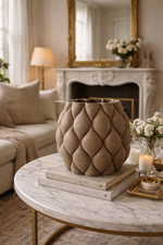 Decorative vase on a marble table in a living room with a fireplace and mirror.