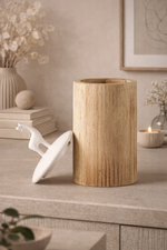 Wooden vase on a table with decorative items in a home setting