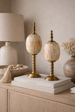 Decorative table lamps on a wooden surface with a neutral background