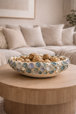 Decorative bowl with pebbles on a wooden coffee table in a living room.