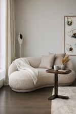 Modern living room with a beige sofa, small table, and decorative items.