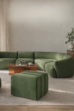 Modern living room with a green sectional sofa and matching ottoman.