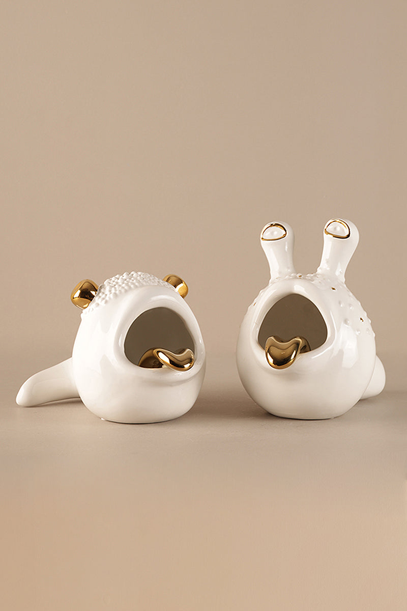 Modern white porcelain sculptural decor accent with gold detailing displayed on neutral background