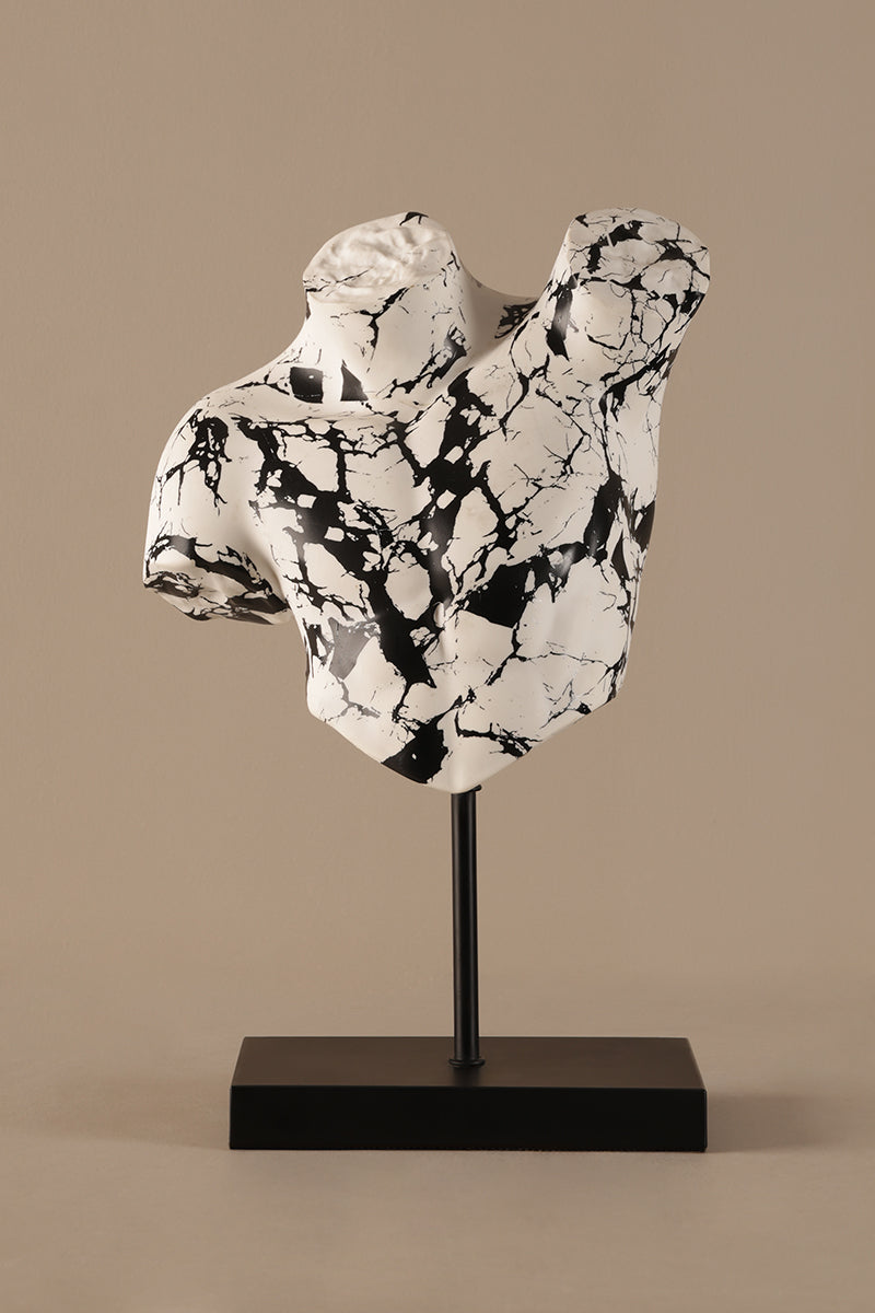 Artistic torso sculpture showing black marble veining on white surface
