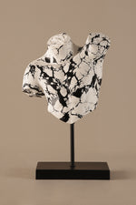 Artistic torso sculpture showing black marble veining on white surface