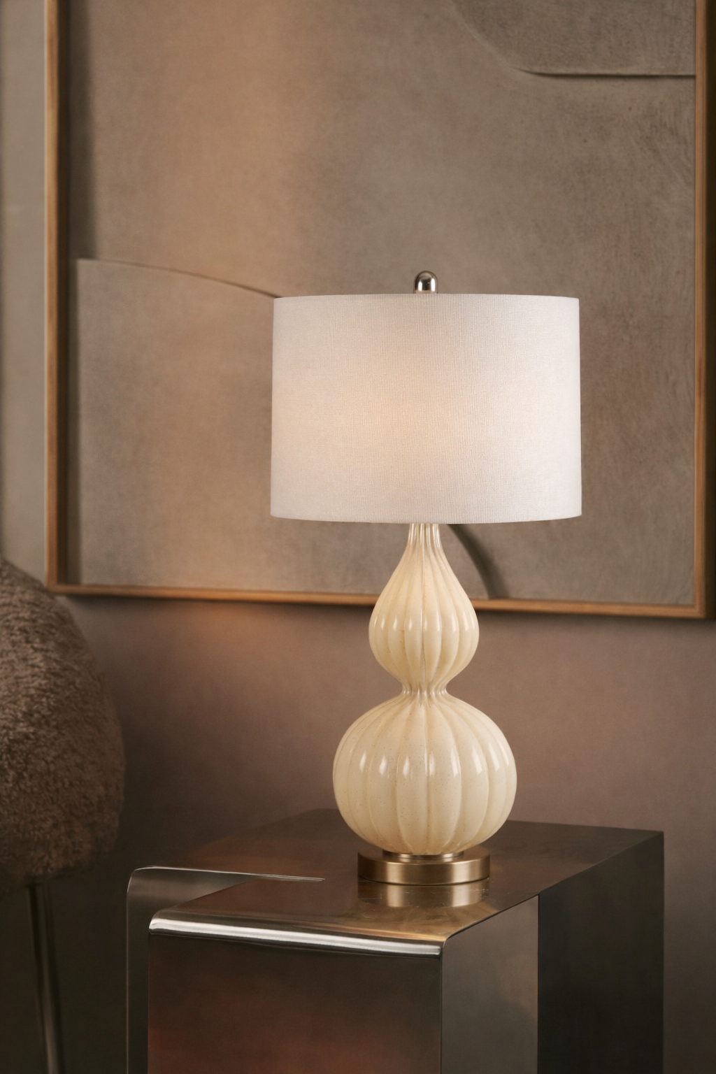 Decorative table lamp with a ribbed design on a reflective surface.