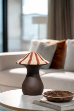 Ceramic vase with striped design on a table in a living room setting