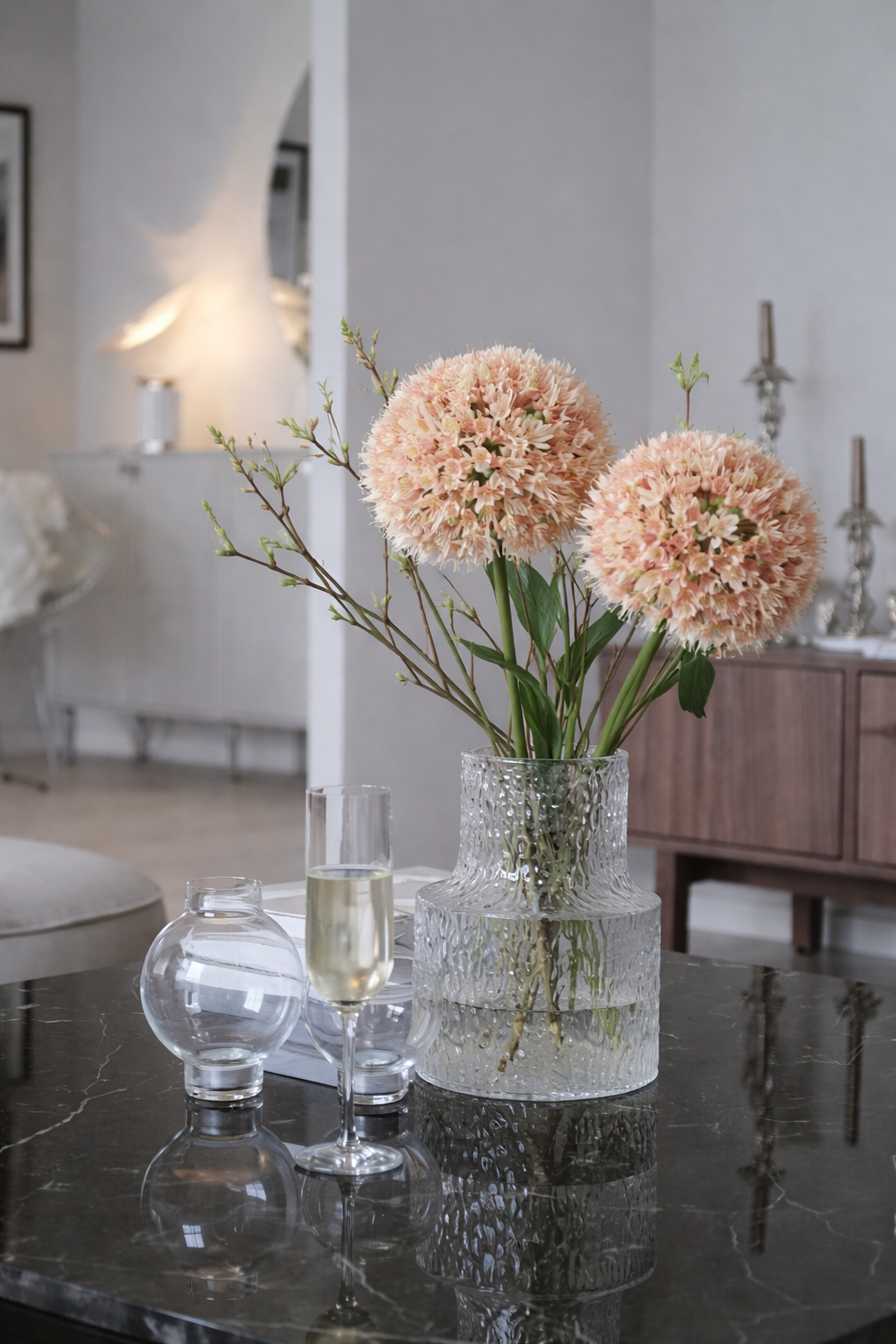 Decorative vase with pink flowers on a table in a modern living room.