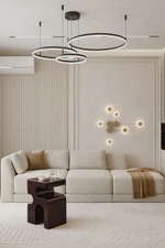 Modern living room with a sectional sofa, coffee table, and decorative wall lights.