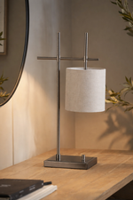 Table lamp with a beige shade on a wooden surface, with a blurred background