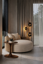Modern living room with a round beige sofa, side table, and wall sconces.