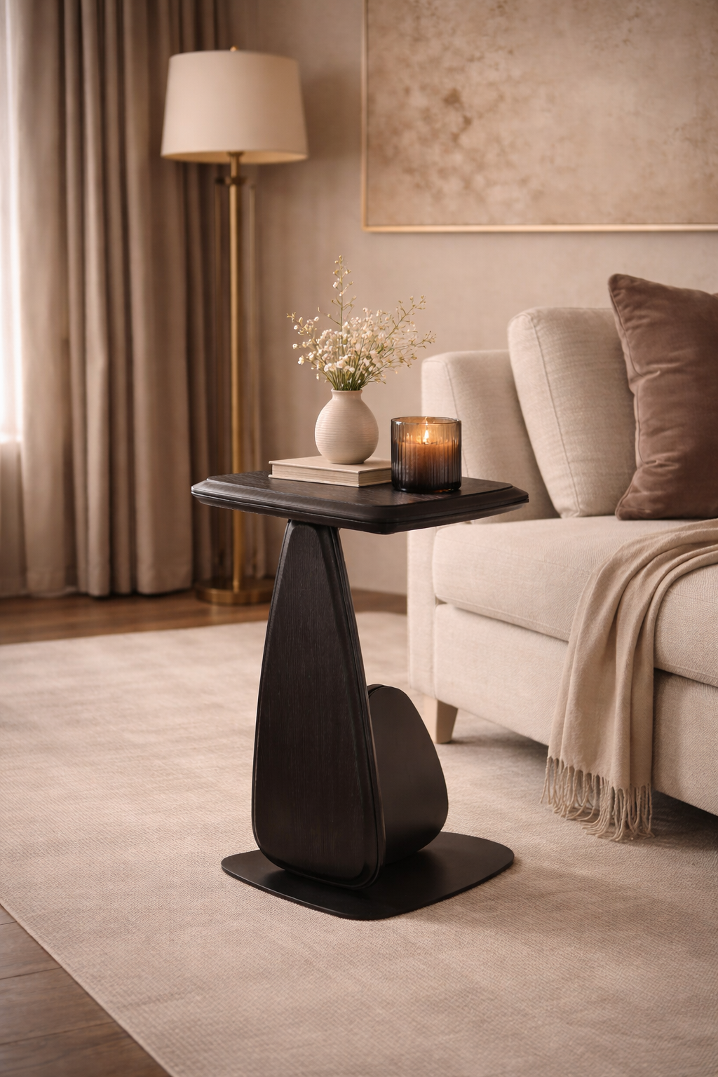 Modern black side table in a living room setting with a lamp, candle, and vase.