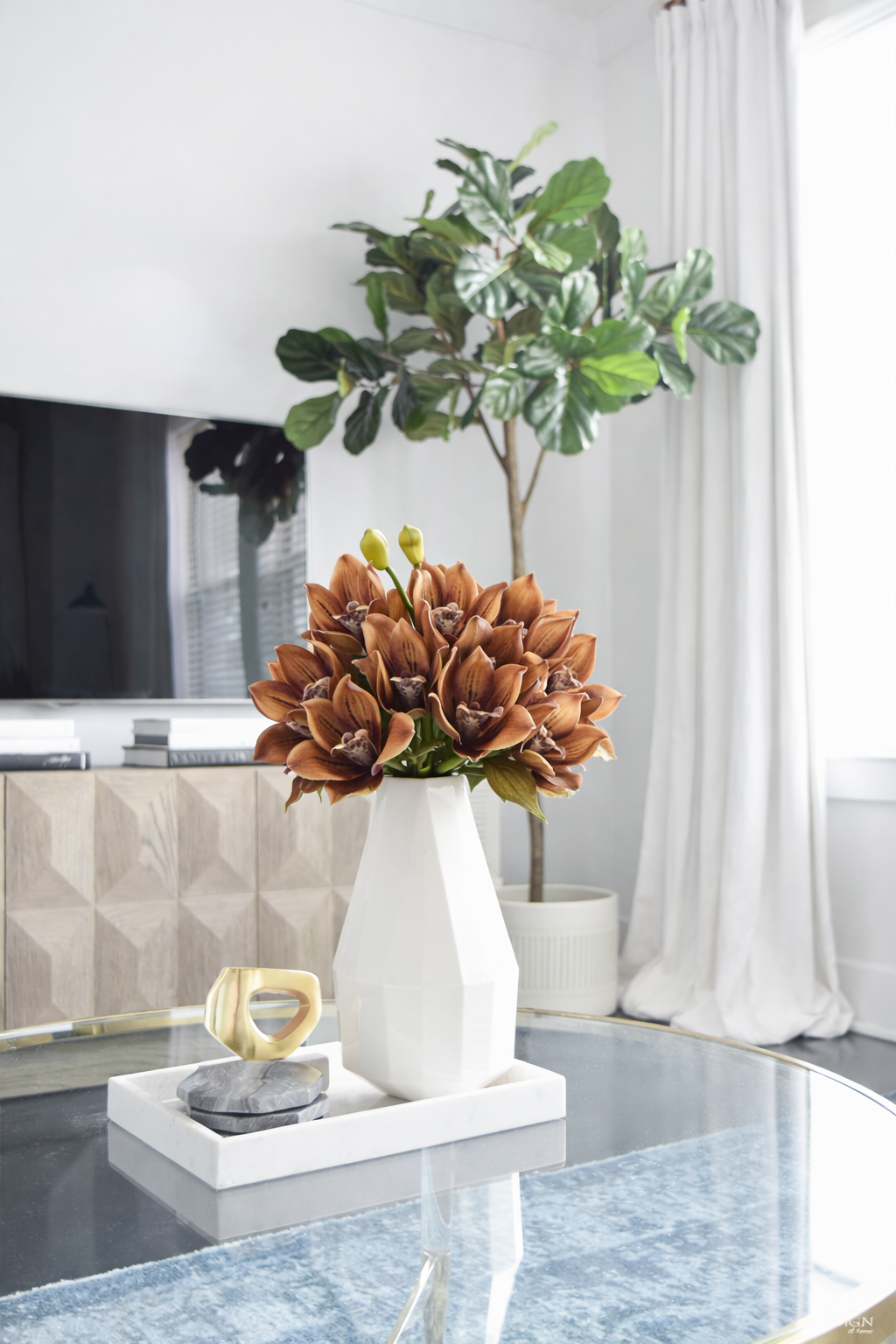 Decorative setup with a vase of flowers on a coffee table in a living room.