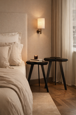 Bedroom with a bed, nightstands, and wall lamp.