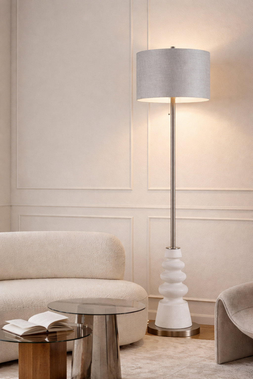 Modern floor lamp with a gray shade in a stylish room with a sofa and table.