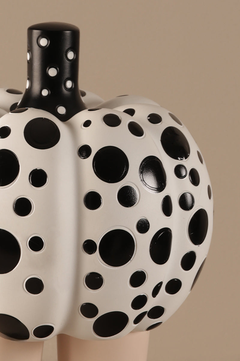 Modern ceramic pumpkin sculpture showing black polka dot detailing