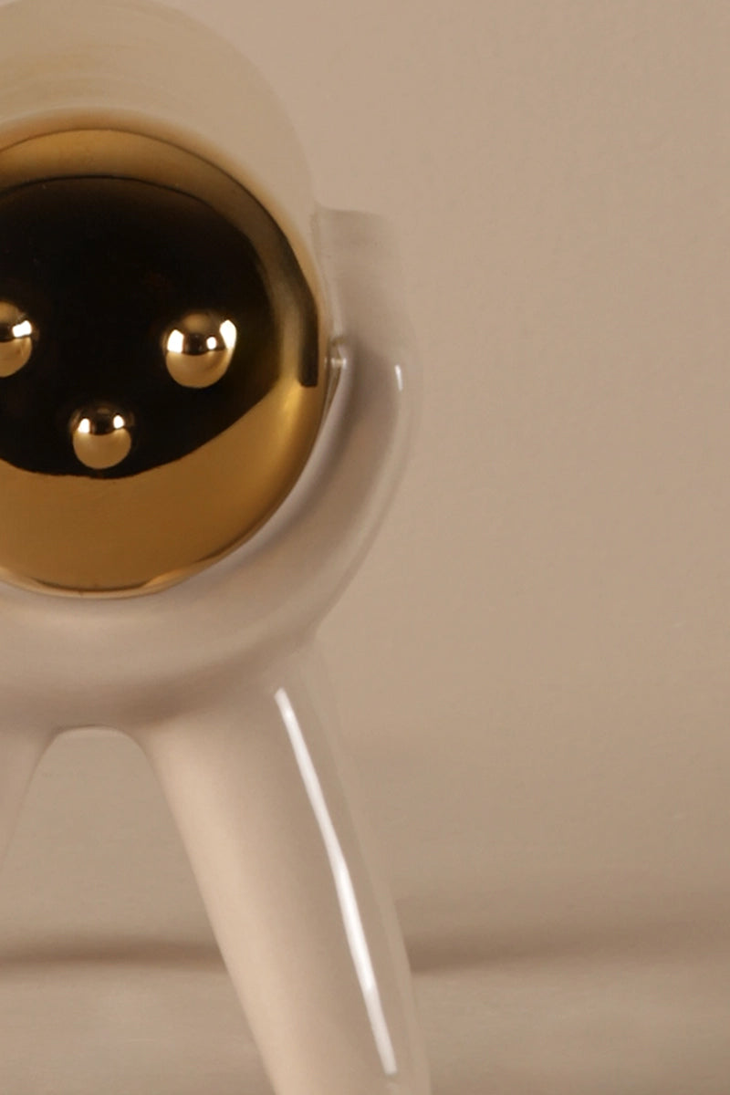 Ceramic sculpture showing smooth beige finish and reflective gold top