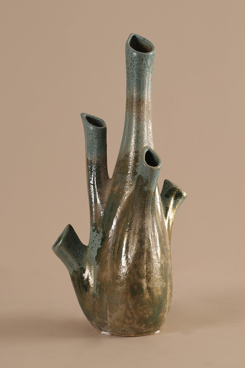 Bronze vase with multiple outlets on a beige background