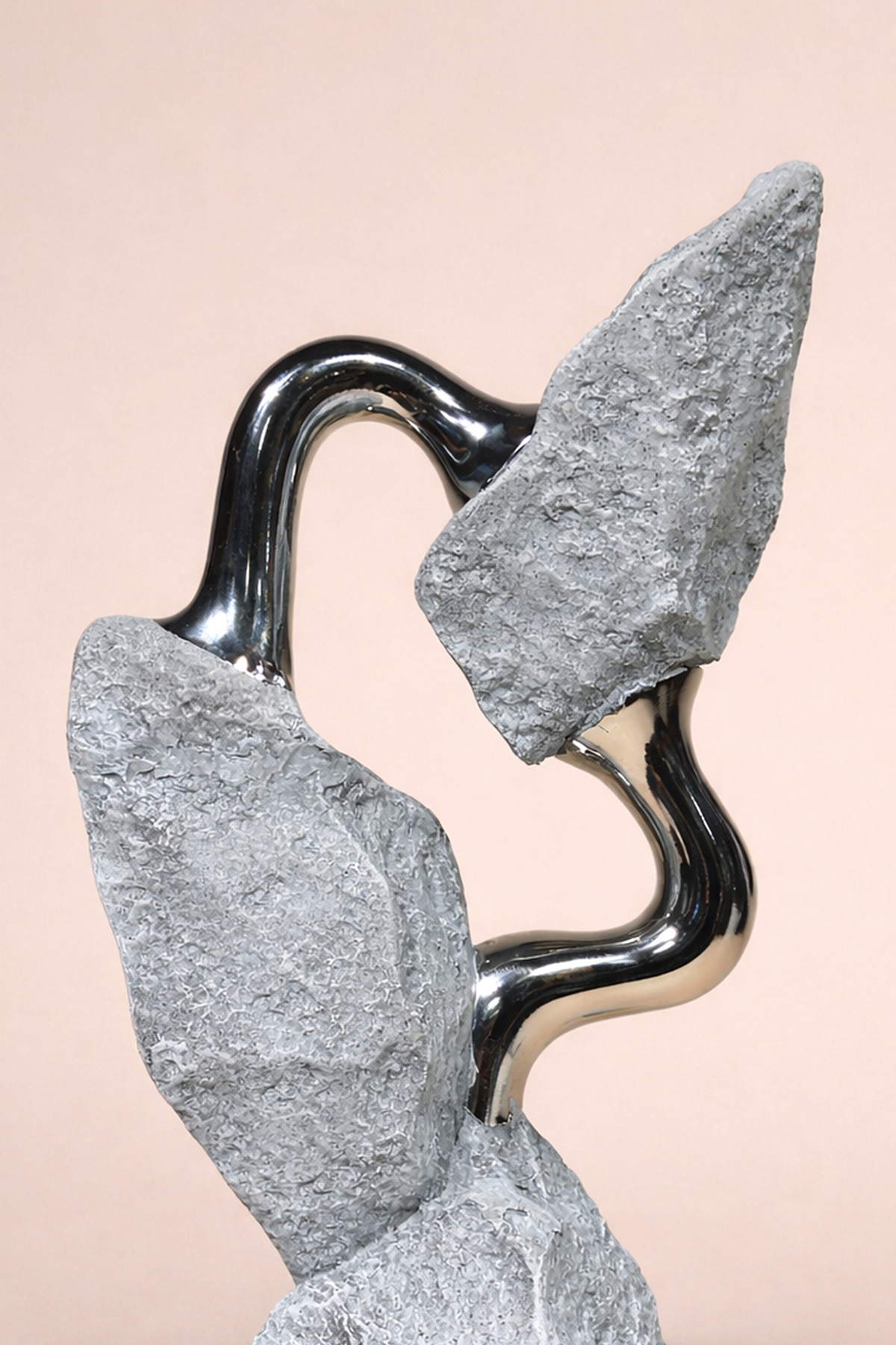 Abstract sculpture with wavy black and gray forms on a beige background