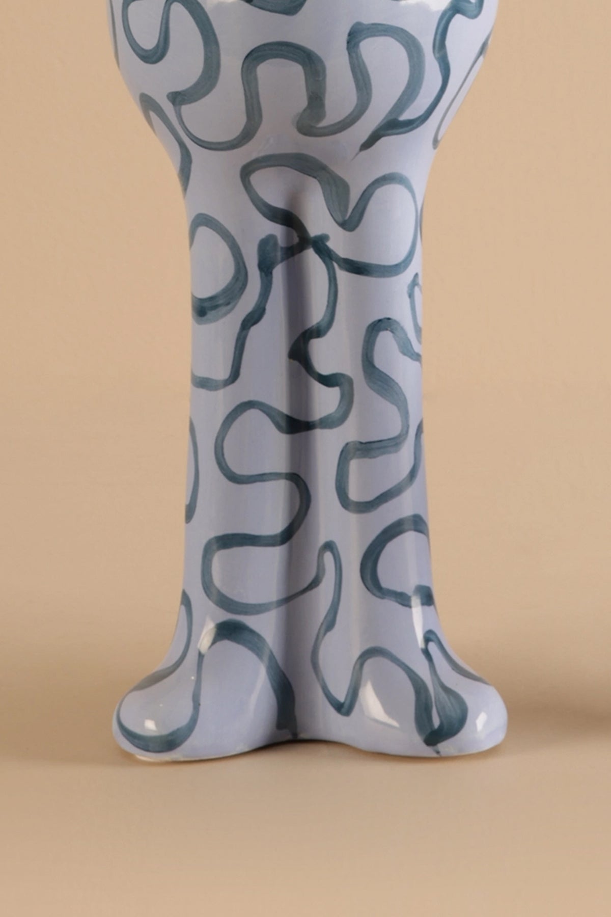 Ceramic vase with wavy pattern on a beige background