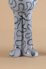 Ceramic vase with wavy pattern on a beige background