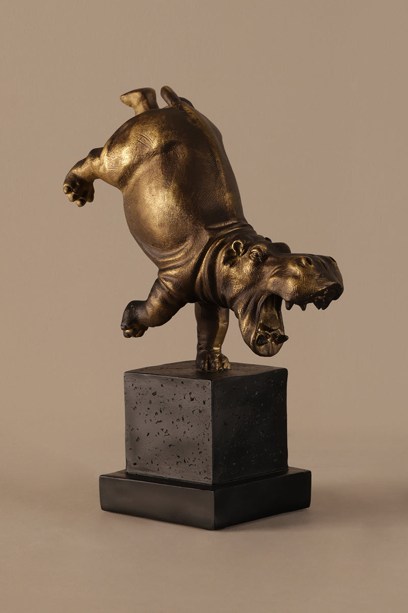Playful hippo decor sculpture with bronze finish displayed on black pedestal