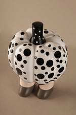 White pumpkin decor sculpture with graphic black dots on neutral legs