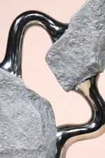 Close-up of a metallic hook with a stone texture on a beige background