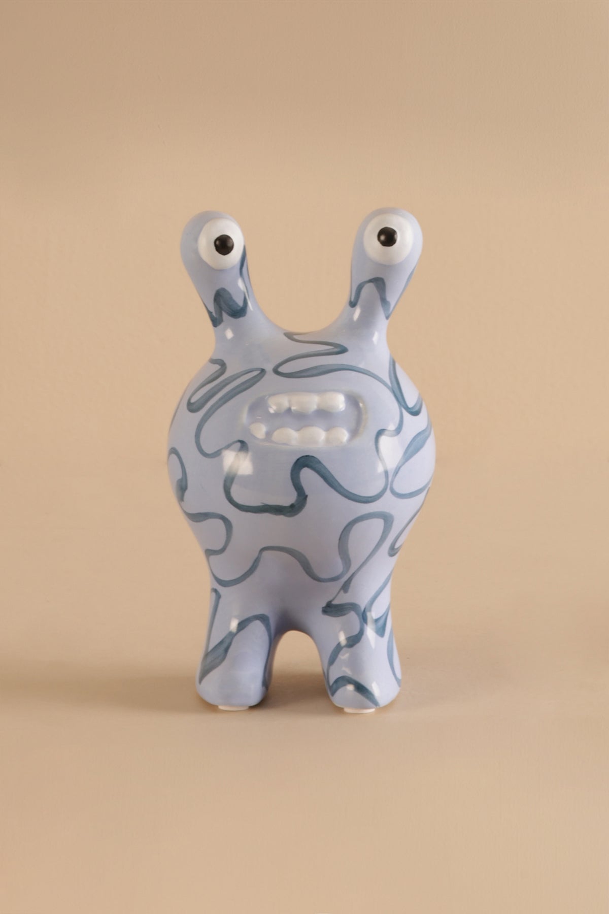 Ceramic decor sculpture showing smooth glaze and hand-drawn style blue patterns