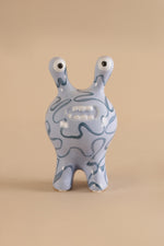 Ceramic decor sculpture showing smooth glaze and hand-drawn style blue patterns
