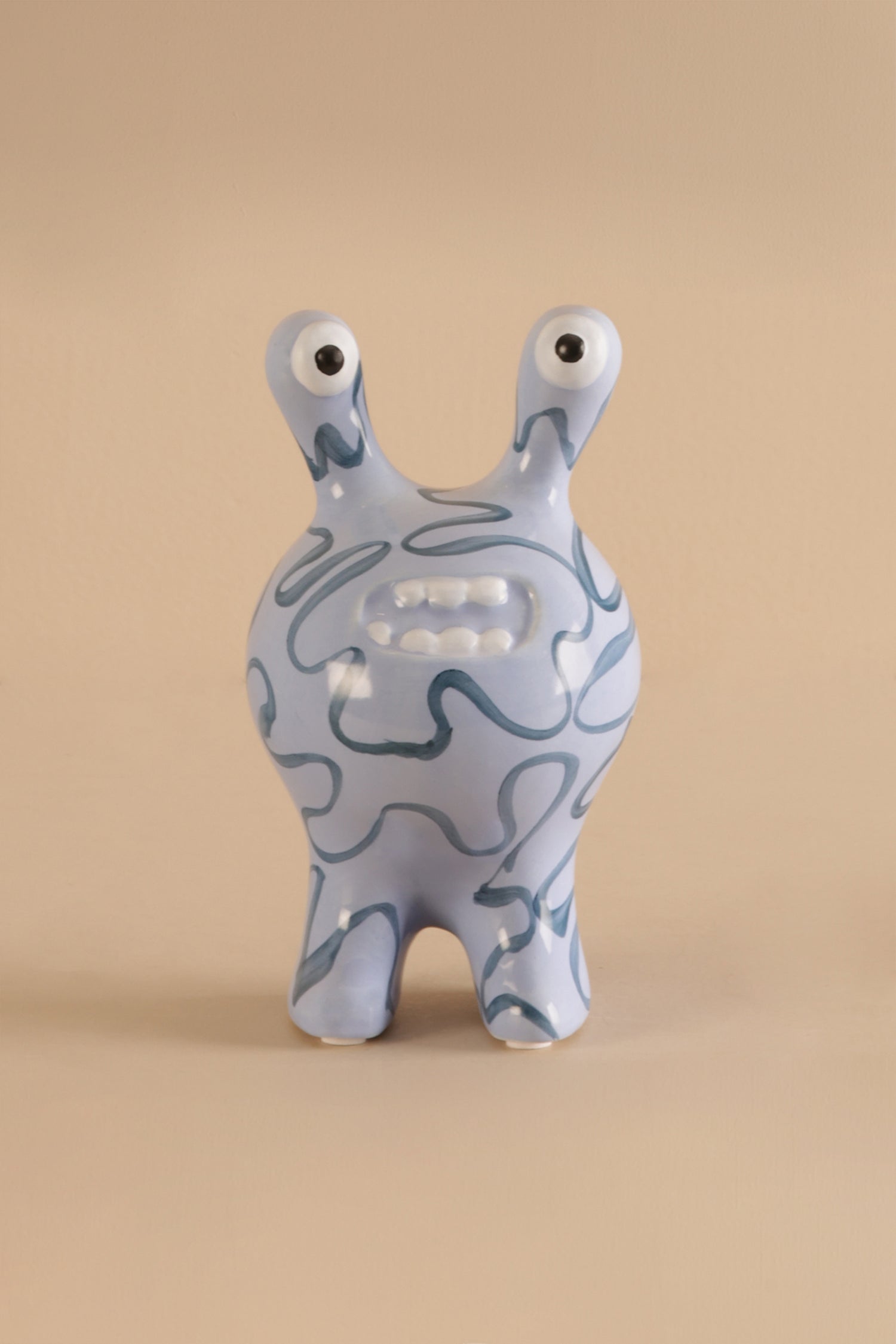 Ceramic decor sculpture showing smooth glaze and hand-drawn style blue patterns