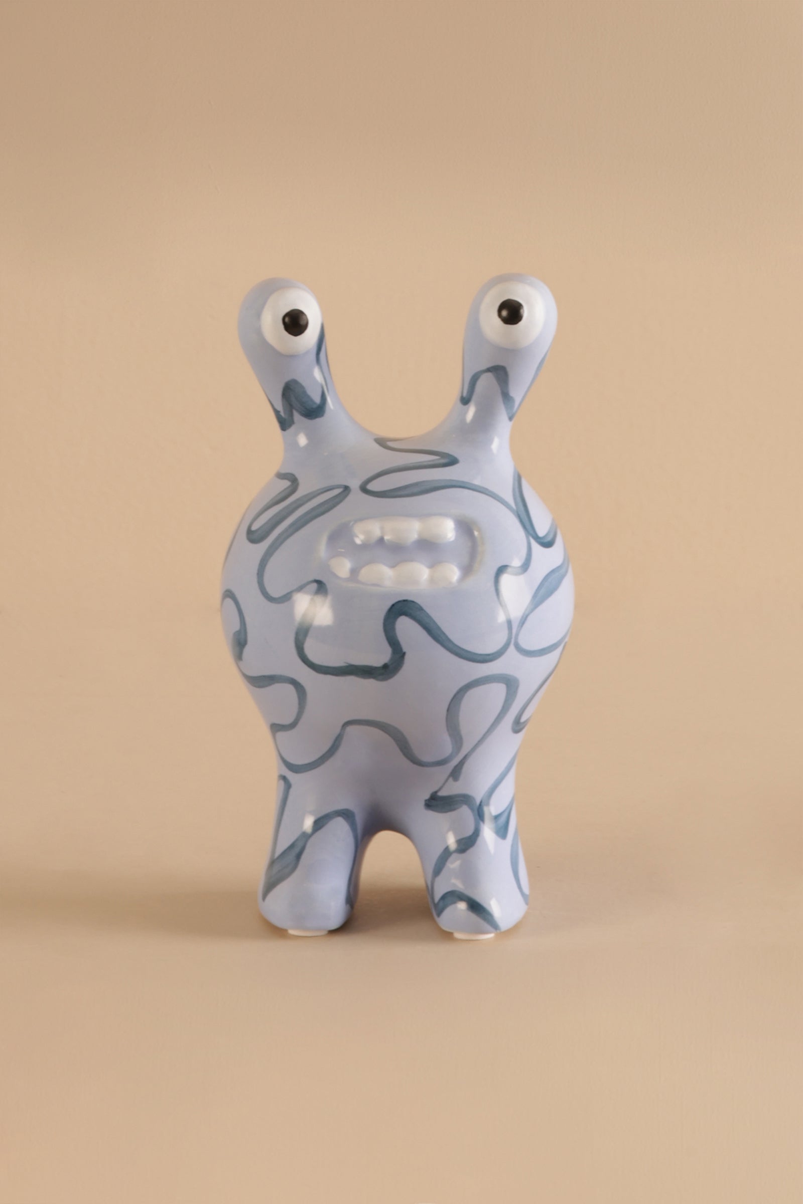 Ceramic decor sculpture showing smooth glaze and hand-drawn style blue patterns