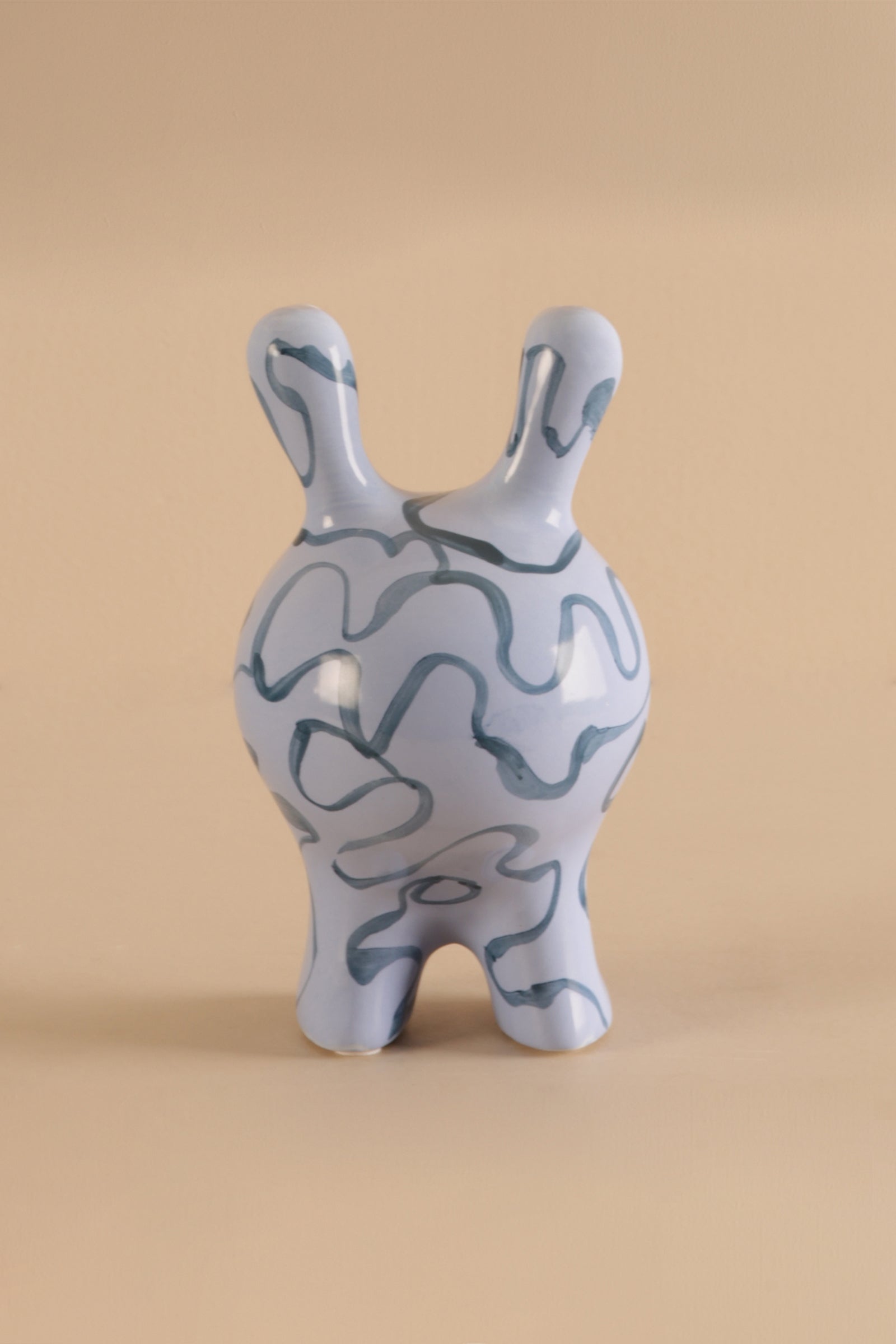 Modern ceramic creature sculpture with glossy blue finish and abstract detailing