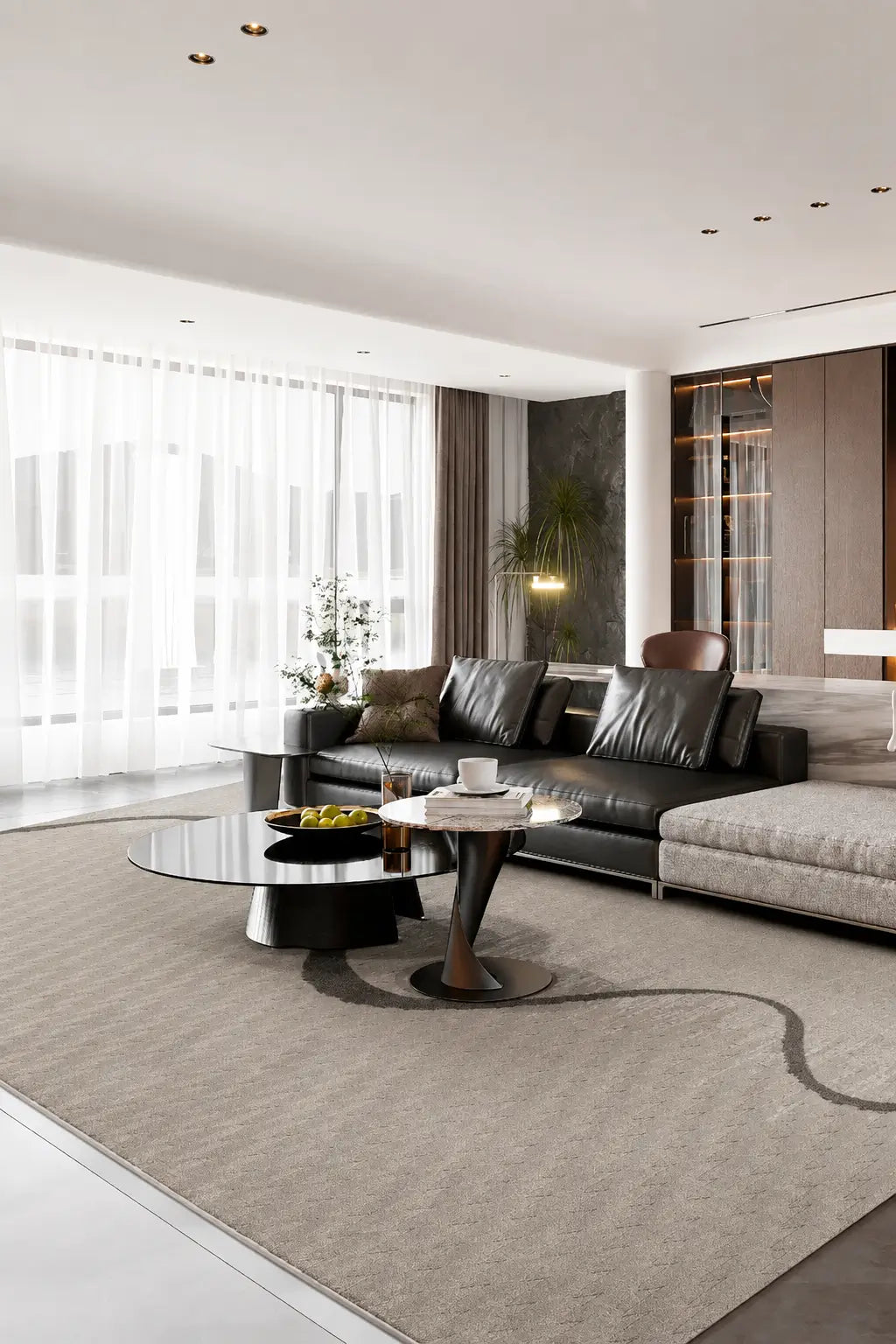 A modern living room featuring a large light beige area rug under a black leather sectional sofa and round coffee tables, with large windows covered in white sheer curtains.