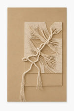 A minimalist beige and cream fiber art piece featuring layered rectangular panels with textured, frayed strands and a knotted rope detail, displayed against a solid tan background.