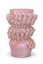 A pink textured ceramic vase with a flared rim and intricate, sculpted ridges, shown on a plain white background.
