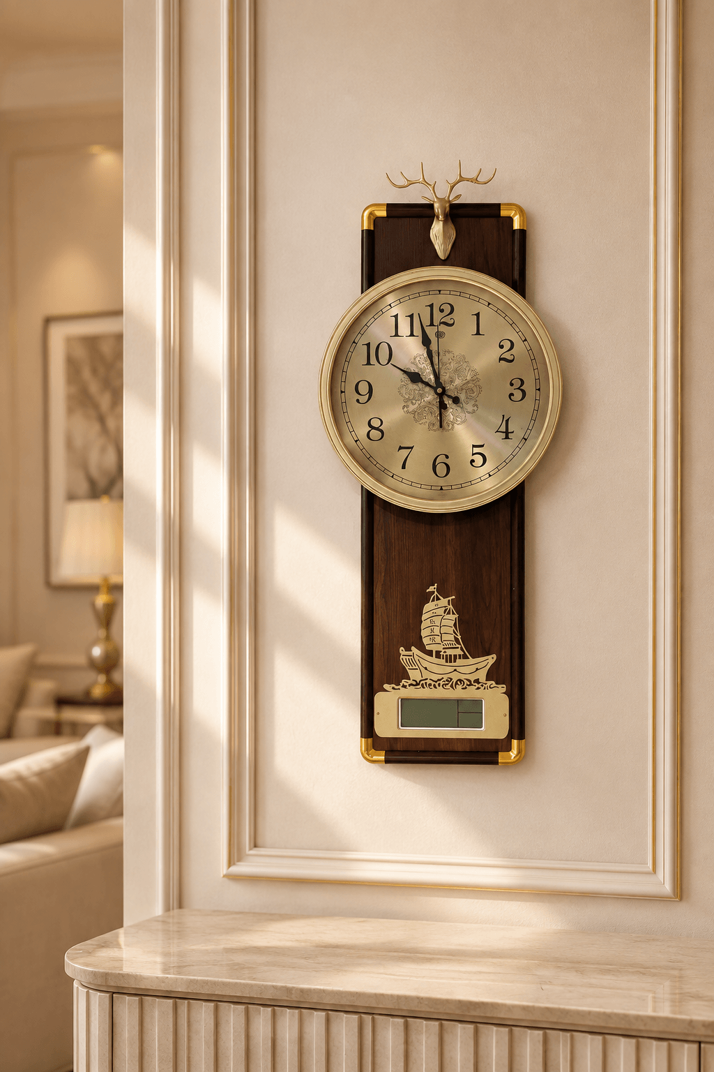 A vertical wall clock with a dark wood and gold-tone frame, featuring a cream-colored dial, a deer head topper, and a gold ship ornament, mounted on a cream-colored paneled wall in a warm, sunlit interior.