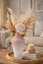 Decorative vase with flowers and candles on a table in a living room setting