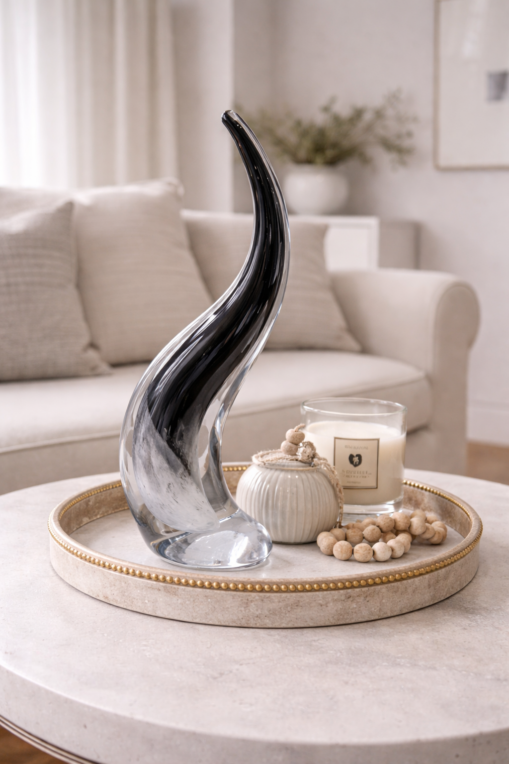 Decorative vase on a tray with candles and beads in a living room setting
