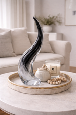 Decorative vase on a tray with candles and beads in a living room setting