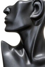 A close-up side profile of a glossy black sculptural bust or mannequin head on a plain white background.