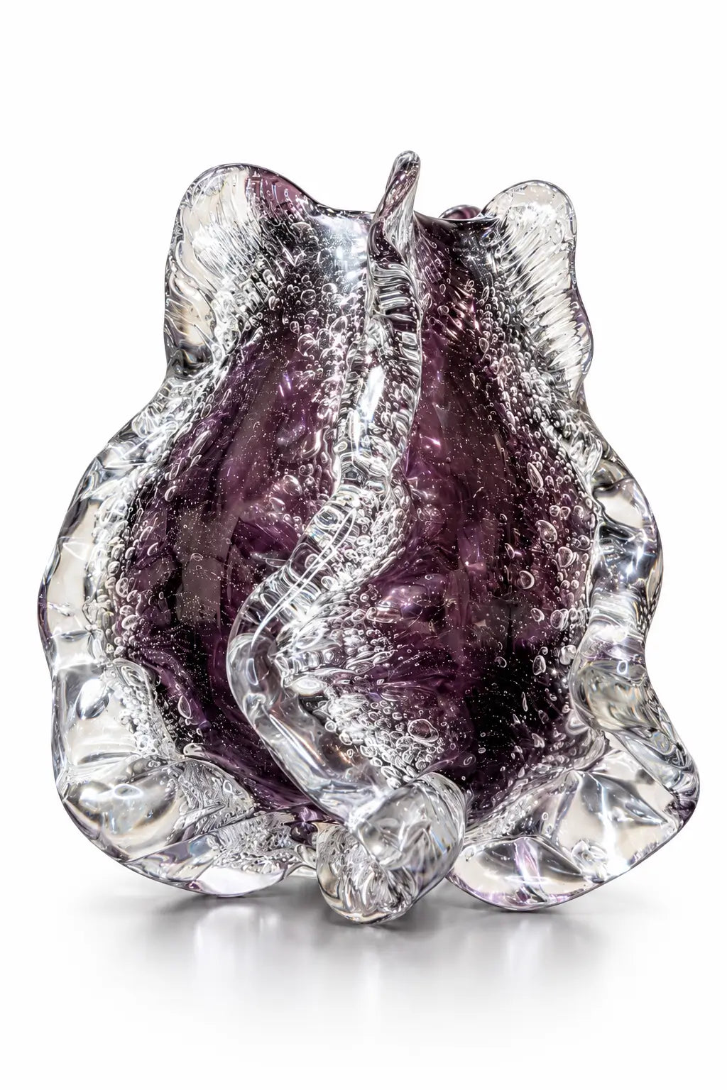 A sculptural, organic-shaped glass bowl with a textured, bubbled finish, featuring a deep purple interior surrounded by clear glass, set against a plain white background.