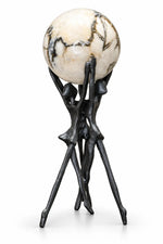 A decorative sculpture featuring a large spherical stone orb with cream, beige, and black marbled patterns, supported by a dark, abstract metal tripod stand shaped like stylized figures.