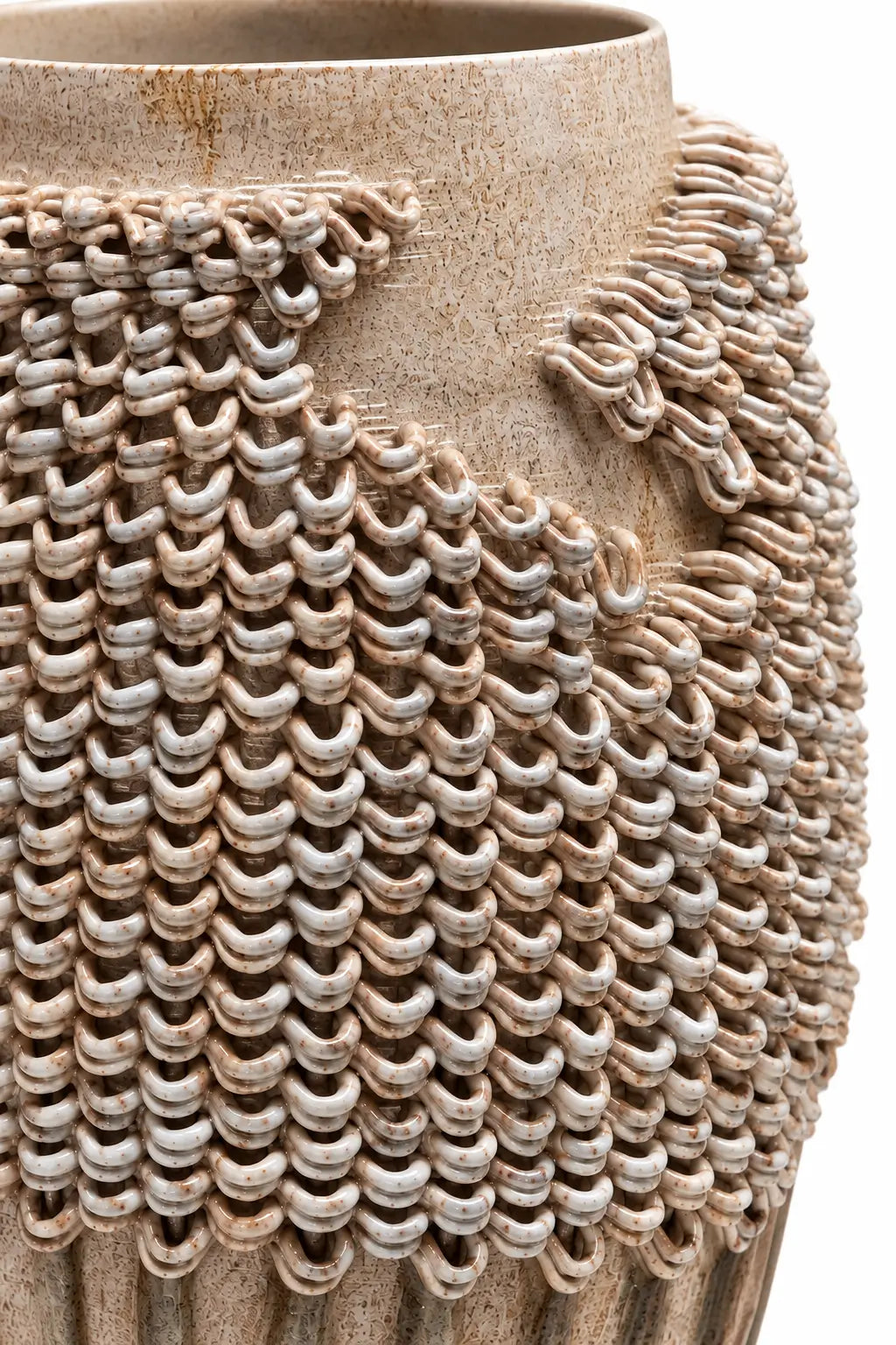 Close-up of a textured ceramic vase with a woven, chainmail-like pattern in earthy beige and gray tones on a white background.