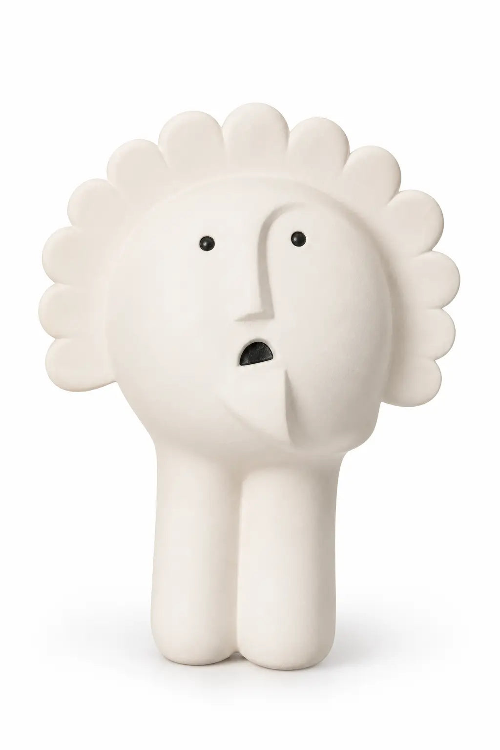 A minimalist, sculptural ceramic figurine of a face with a sunburst or flower-like crown, standing on two legs. The figure is off-white with small black eyes and a black mouth, set against a clean white background.