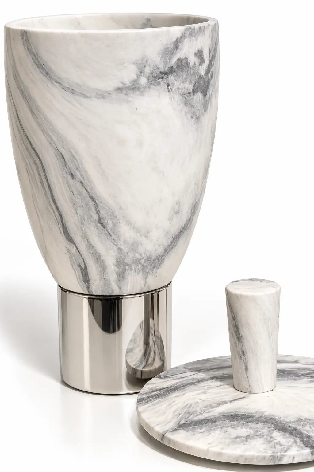 A marble and polished metal bathroom accessory set, featuring a conical cup with a brushed silver base, shown alongside its matching marble lid with a small cylindrical handle on a white background.