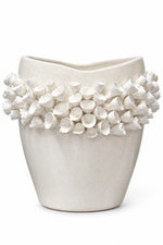 An off-white ceramic planter with a textured, organic shape and a band of small sculpted flower-like protrusions around the upper portion, shown on a plain white background.